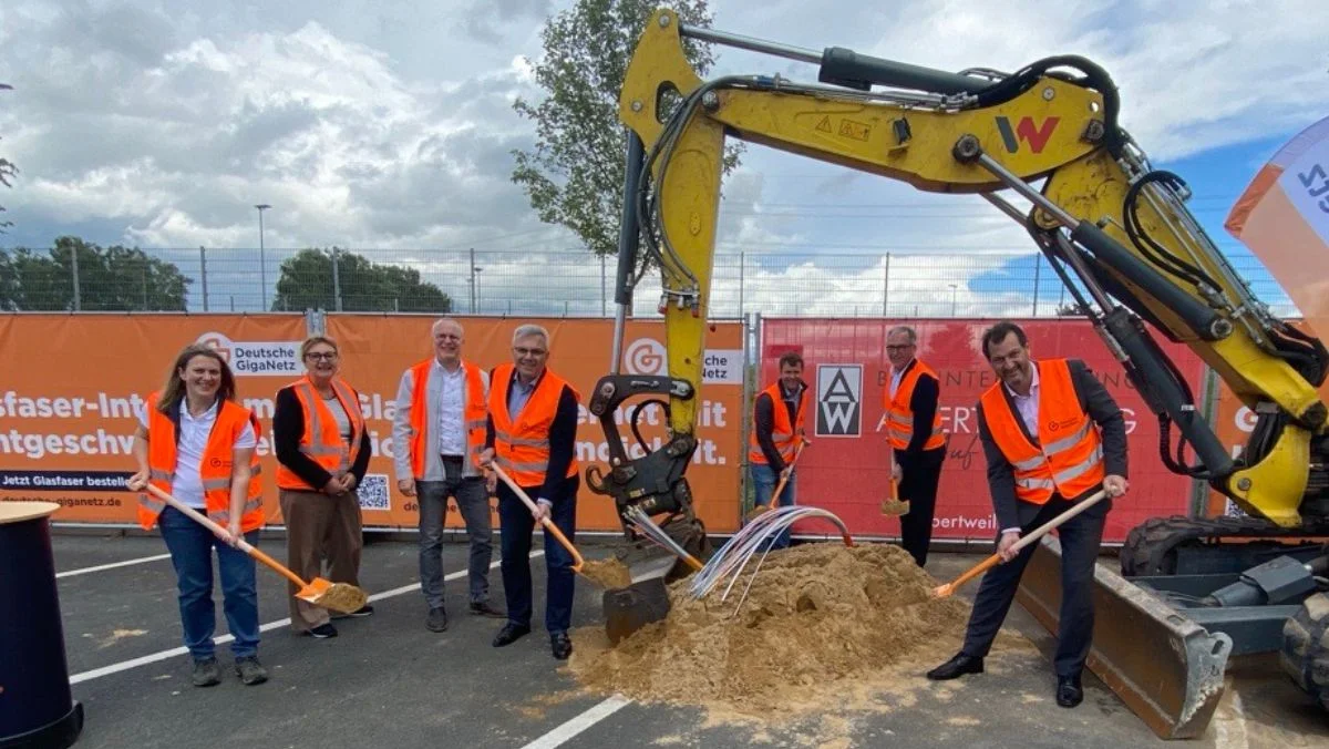 Sieben Personen auf einer Baustelle beim symbolischen Spatenstich